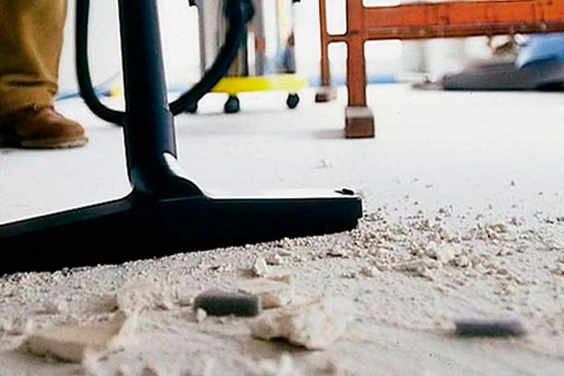 Vacuum clearing construction dust and debris from a floor during post-construction cleanup